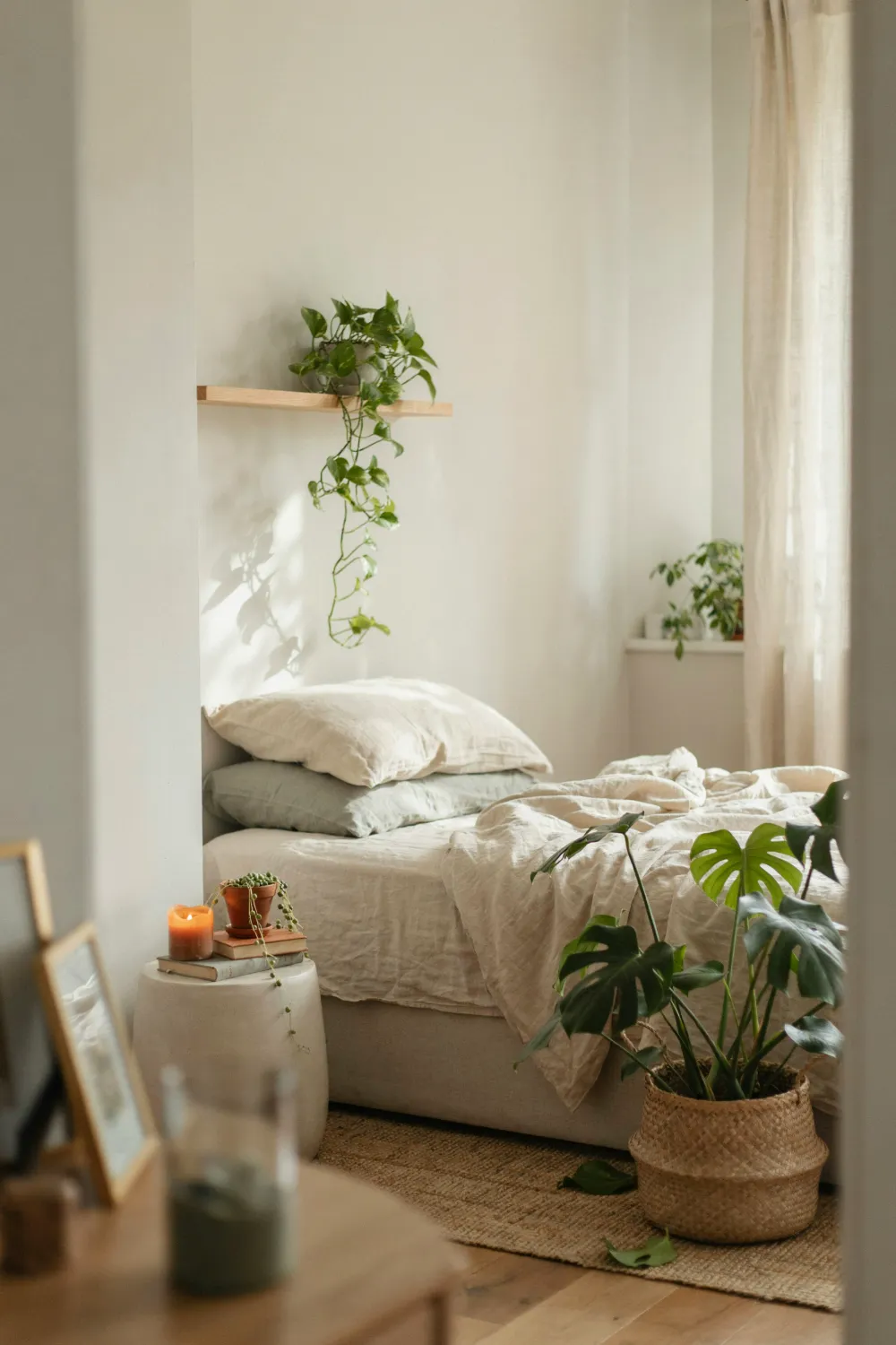 Cozy bedroom filled with trailing pothos and a monstera plant