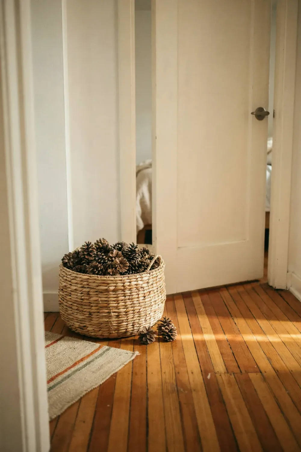 Cozy fall bedroom in warm feminine tones: finish With a Basket of Pinecones by the Door