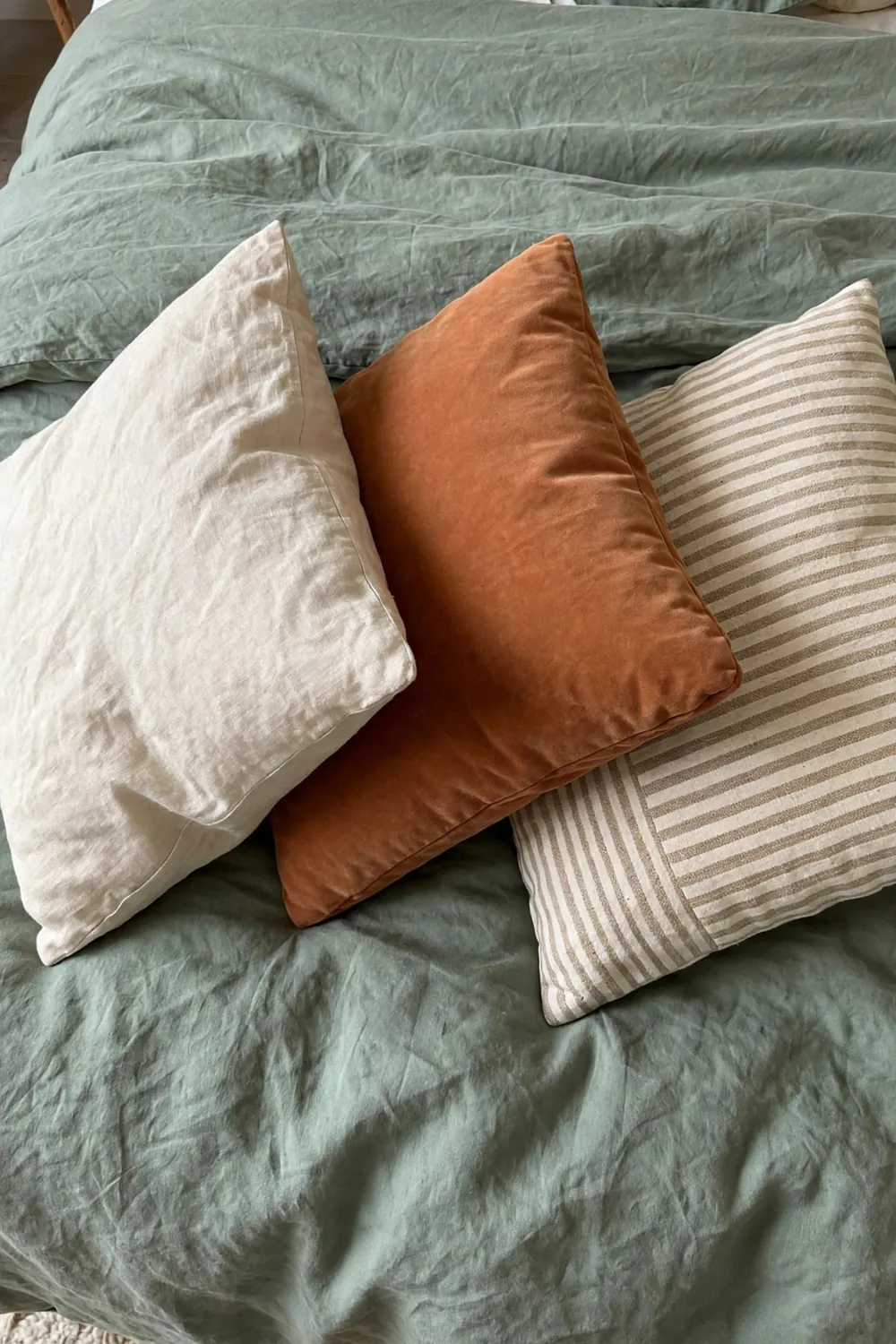 Warm sage green bedroom: choose Cushions in Cream, Clay, and Natural Stripe
